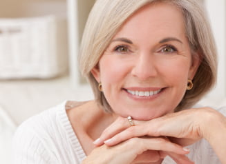 Lady smiling with chin resting on hands